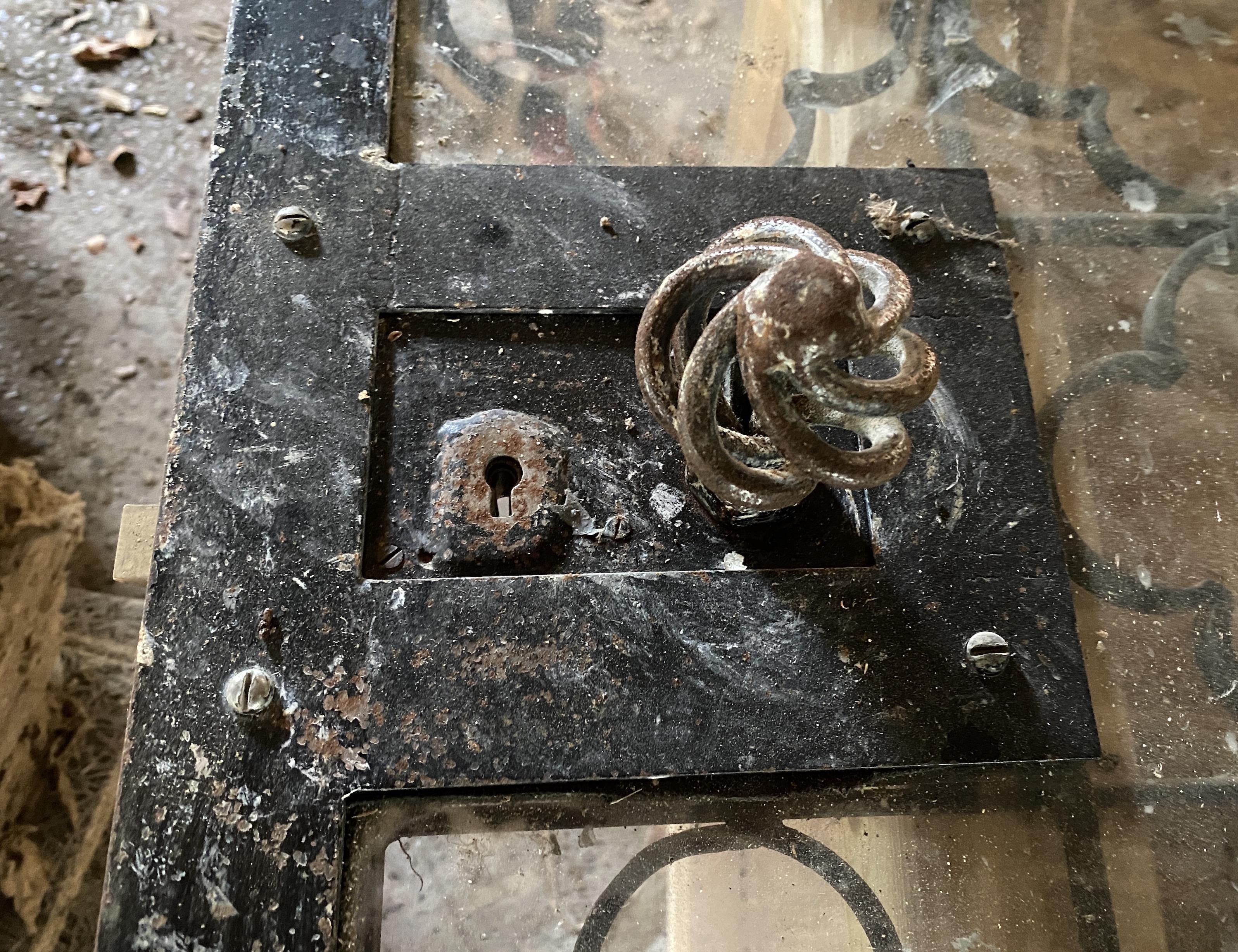 A heavy wrought and cast iron wine cellar security door and lock, with a plate glass inset panel, 186 x 105cm, together a rubber door seal, hinges, coach bolts and sets of keys